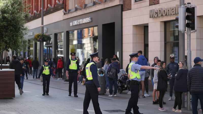 Gardaí on Dublin’s Henry Street as people queue to enter JD Store on June 8th, the first day of re-opening of non-essential retail stores. Photograph: Nick Bradshaw for The Irish Times