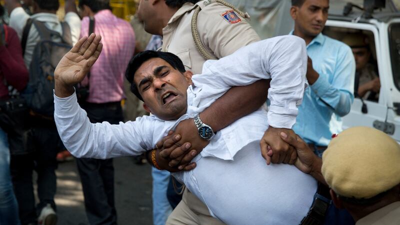 An Indian policeman takes away a Congress party worker during a protest against Akbar in New Delhi. Photograph: Manish Swarup/AP Photo