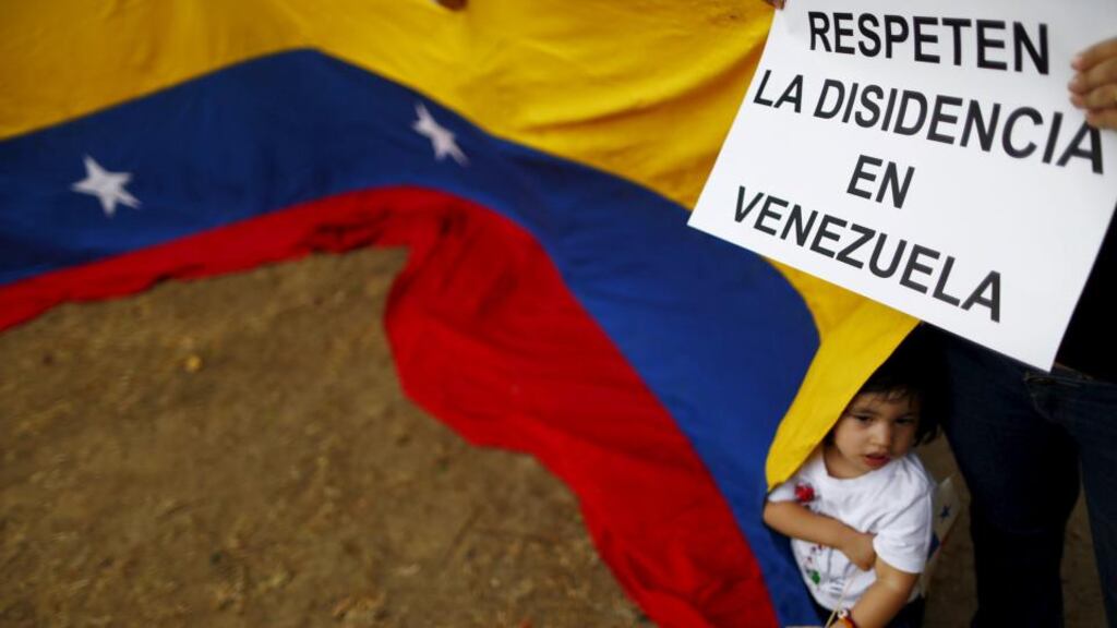 A girl stands behind a Venezuelan flag and underneath a sign reading “Respect Dissidence in Venezuela” during a protest in Panama City ahead of this weekend’s Summit of the Americas. Photograph: Edgard Garrido/Reuters