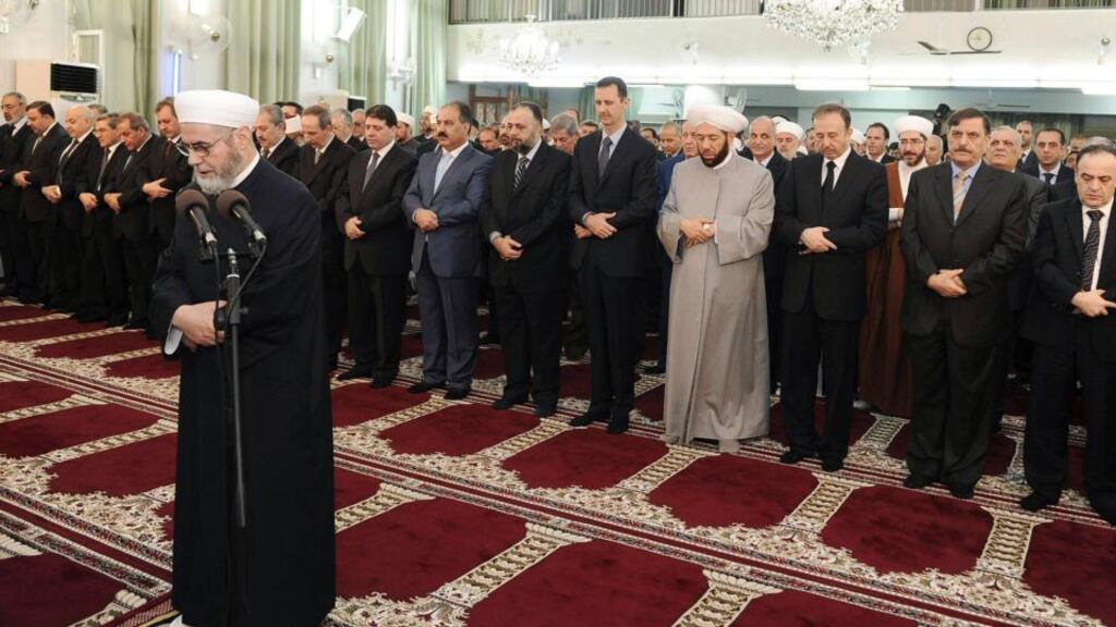Syria’s president Bashar al-Assad (centre) taking part in Eid al-Fitr prayers at Anas bin Malek mosque in Damascus yesterday. Photograph: Reuters/Sana/Handout