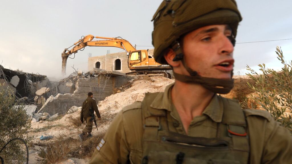 Israei soldiers at the scene as a  bulldozer demolishes a Palestinian house in Yatta village, south of the city of Hebron, on October 17th.   Israeli adminstrative control bans Palestinians from erecting buildings and infrastructure in Area C of the West Bank. Photograph: Abed al-Hashlamoun/EPA