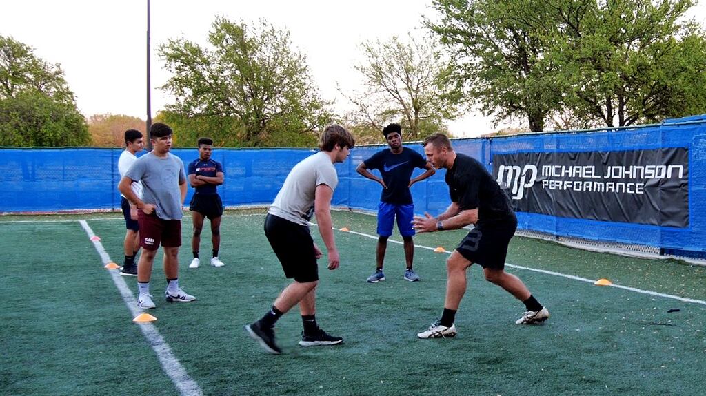 Roger Wilson works with high school footballers on tackle technique in Texas.