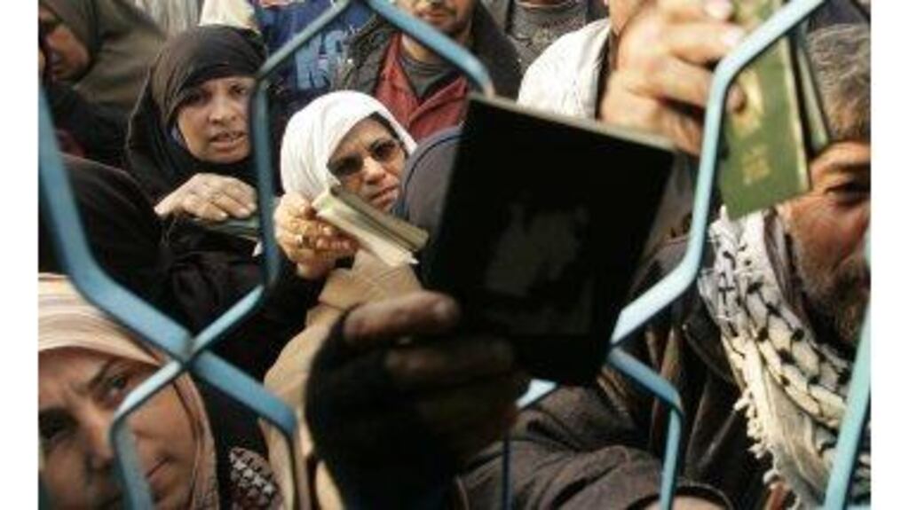 Palestinians presenting passports after the Rafah border between the Gaza Strip and Egypt was reopened yesterday. The crossing was cleared after the Palestinian Authority negotiated an end to an armed police blockade.