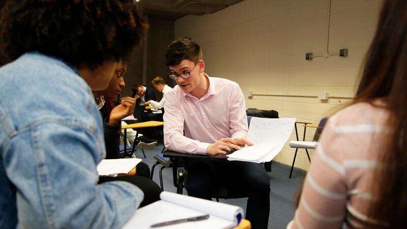 Volunteer tutor Chris Byrne with students at Project Sums, a free maths grinds club at Trinity College Dublin. Photograph: Nick Bradshaw.