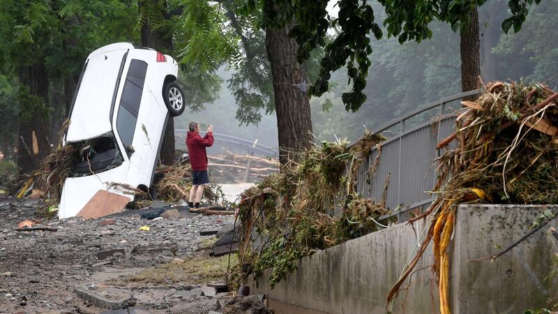 A man standing next to a destroyed car takes pictured of the devastated area after the floods caused major damage in Bad Neuenahr-Ahrweiler. Photograph: AFP via Getty Images