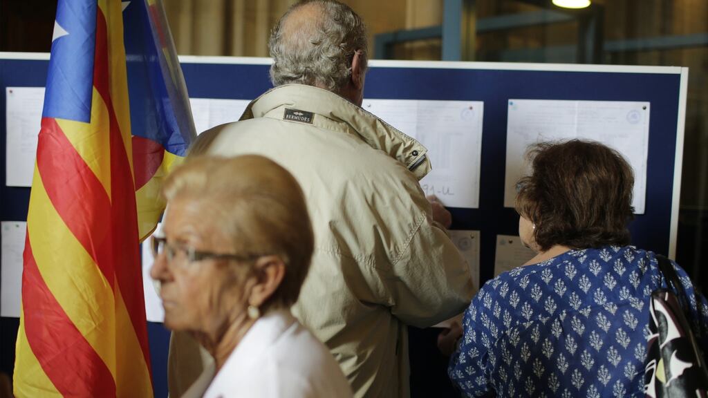 Voters check a notice board for information ahead of registering their vote during the Catalonian parliamentary election in Barcelona, Spain, on Sunday, Sept. 27th, 2015. Catalans began voting on Sunday in an election that may determine whether the region pushes ahead with its campaign to break away from Spain and create a new European state. (Photograph: Pau Barrena/Bloomberg)