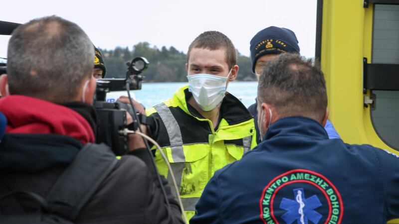 A survivor from the still burning Euroferry Olympia is escorted by Greek coast guards as he arrives at the port of Corfu island, northwestern Greece. Photograph: Stamatis Katopodis/InTime News via AP