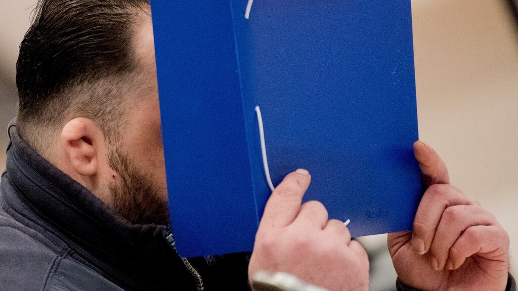 Former nurse Niels Hoegel covers his face as he arrives for the start of his trial in a courtroom in Oldenburg, Germany on Tuesday. Photograph: Julian Stratenschulte/Pool via Reuters