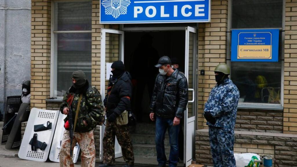 Armed men stand in front of the police headquarters building in Slaviansk today. Photograph: Gleb Garanich/Ukraine