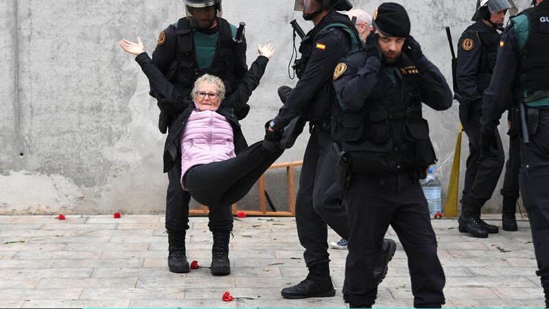 An elderly woman is removed by force as police move in on the crowds.Photograph:David Ramos/Getty Images