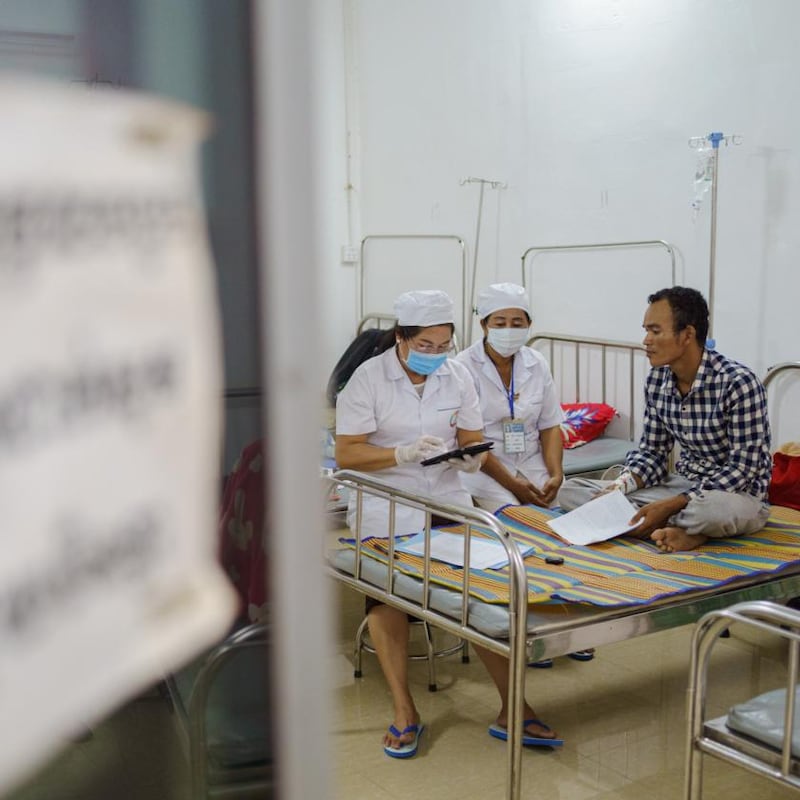 Sreng Sokunthea (left), a lab technician, interviews Siv Vath, a garment worker who had a high fever. His blood was analysed and put through a genetic sequencer in Dr Manning’s lab. Photograph: Thomas Cristofoletti/New York Times