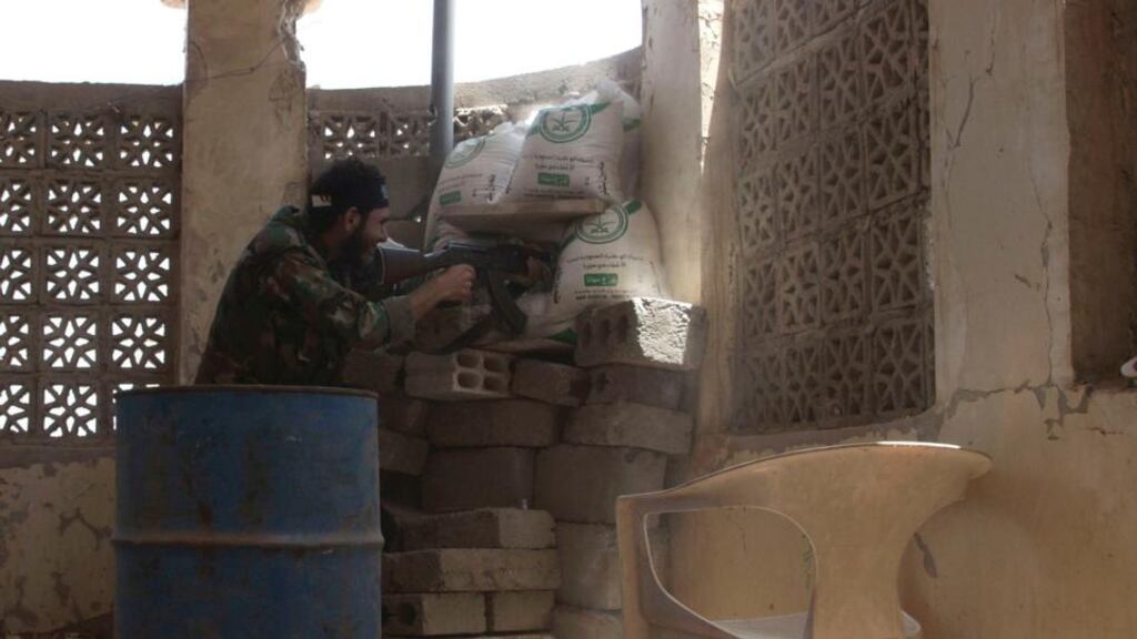 A member of the Free Syrian Army aims his weapon as he takes up a defensive position in Deir al-Zor. Photograph: Khalil Ashawi/Reuters