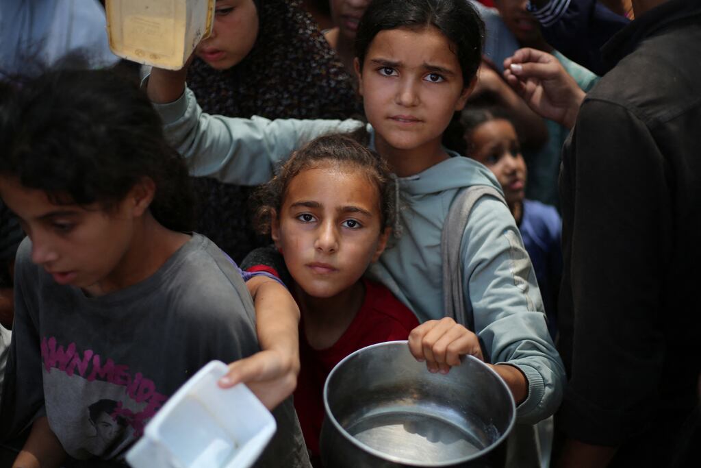 Palestinian children queue for a portion of hot food at the Nuseirat refugee camp in central Gaza on Tuesday. Photograph: Eyad Baba/AFP via Getty Images