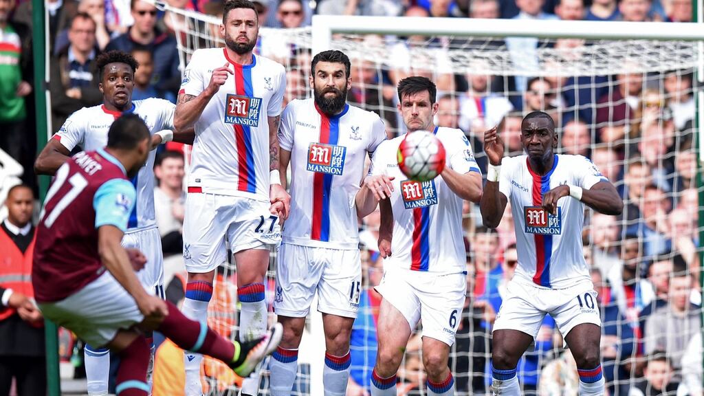 The Crystal Palace wall prepares to jump to block West Ham United’s French midfielder Dimitri Payet’s freekick but cannot prevent him. Photograph: Getty Images