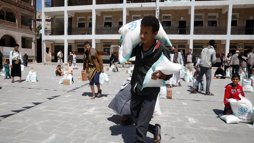A Yemeni carries his share of food aid provided by an aid agency amid heightened food insecurity in Sana’a, Yemen. Photograph: Yahya Arhab/EPA