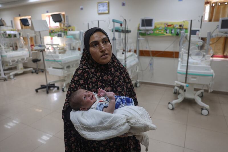 A Palestinian woman prepares to evacuate with her newborn from the Al-Aqsa Martyrs Hospital in Deir al-Balah in the central Gaza Strip. Photograph: Eyad Baba/AFP via Getty Images