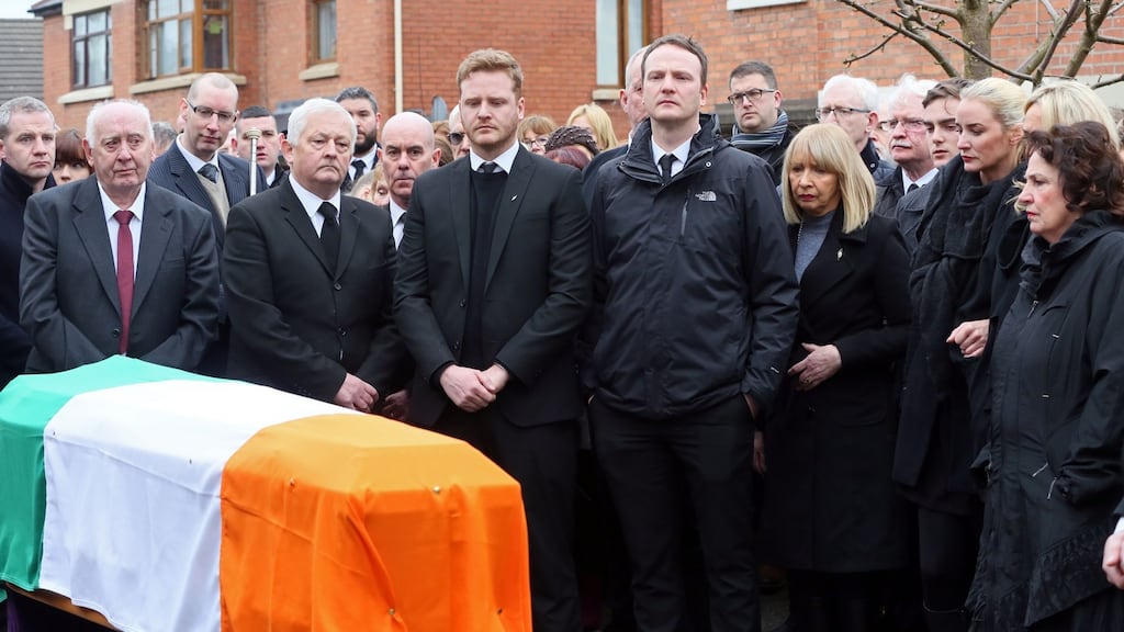 An Irish flag is placed upon the coffin as sons Emmet (centre left) and Fiachra (centre right), wife Bernadette (Bernie, far right) look on ahead of the funeral of Martin McGuinness outside his home in the Derry. Photograph: Paul Faith/PA Wire