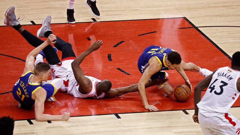 Toronto Raptors player Serge Ibaka goes for a loose ball against Golden State Warriors players Jonas Jerebko and Klay Thompson during the second half of the NBA Finals game one at Scotiabank Arena in Toronto, Canada. Photo: Larry W Smith/EPA
