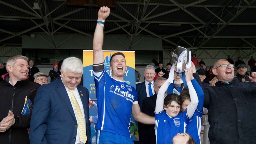 Thurles Sarsfields captain Pádraic Maher raises the Tipperary senior hurling trophy with daughters of the club’s deceased trainer Jackie Griffin, Laragh, Isabelle and Emma, after the win over Kiladangan at Semple Stadium earlier this month.  Photograph: Morgan Treacy/Inpho.