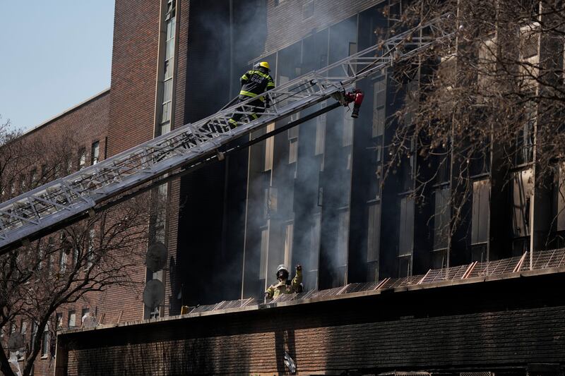 Fire marshals inspect the scene of the deadly blaze in Johannesburg. Photograph: Theme Hadebe/AP
