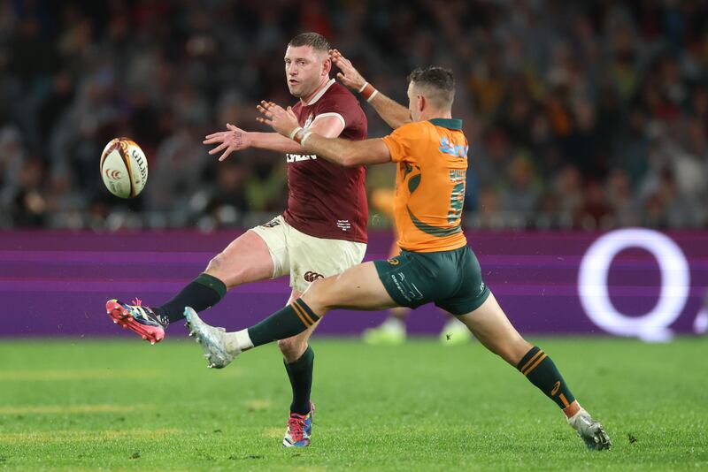 Finn Russell kicks the ball under pressure from Nic White. Photograph: David Rogers/Getty