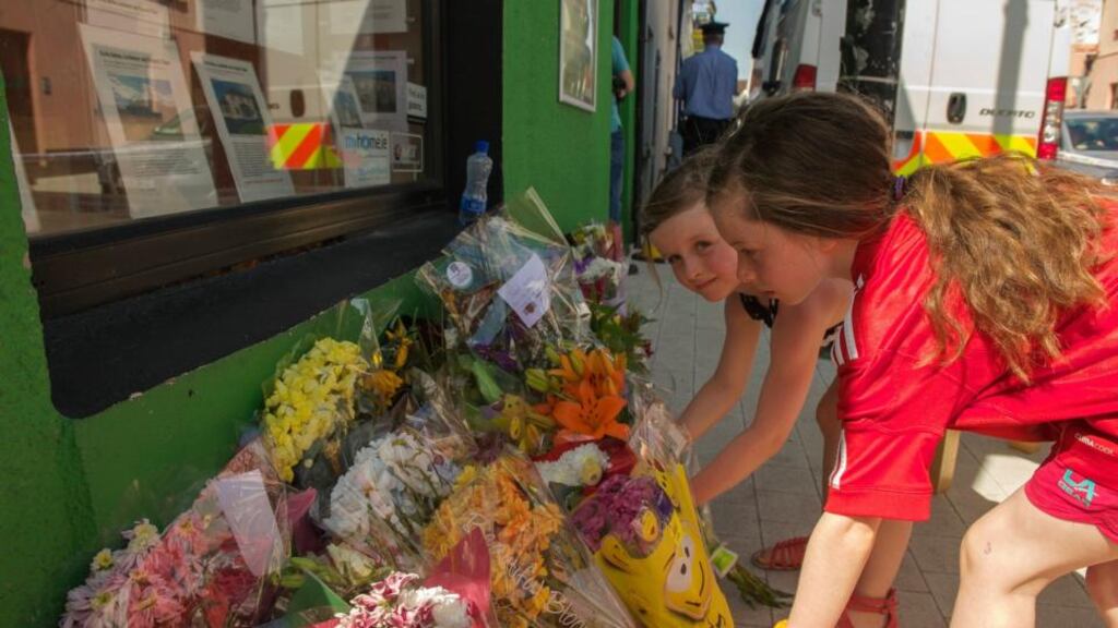 Mary Kate (9) and Sarah (7) Murrihy, placing flowers at the home of brothers Tom and Jack Blaine. Photograph: Keith Heneghan/Phocus