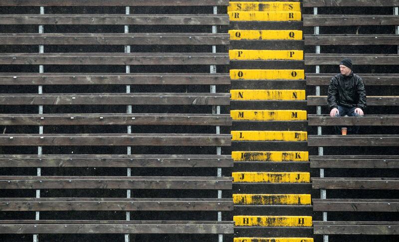 A lone spectator sits in the stands watching a game in an empty section of seats. Photograph: Morgan Treacy/Inpho