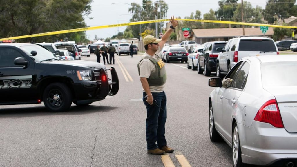 An FBI agent stands at one of the sites of a multiple location shooting in the Phoenix, Arizona suburb of Mesa that has so far left one dead and five wounded. Photograph: Deanna Dent/Reuters