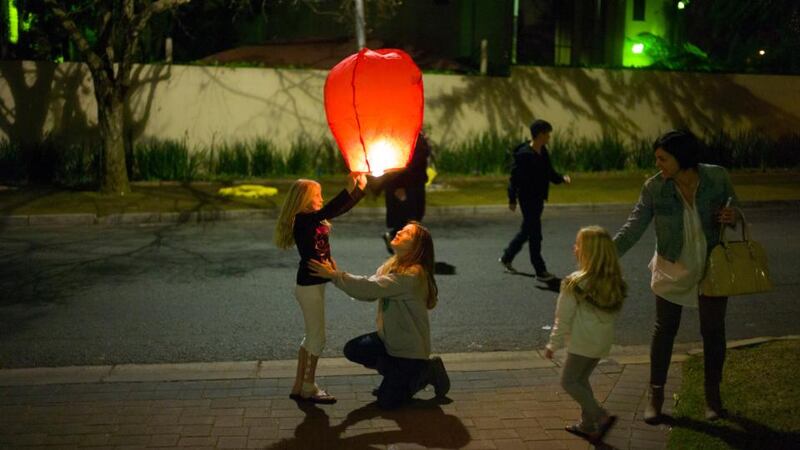 A woman and child launch a sky lantern outside the Mandela home in Johannesburg, South Africa, last night. Photograph: Ozier Muhammad/The New York Times