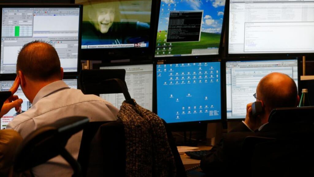 Stock market traders in Frankfurt concentrate on their monitors as a TV shows Angela Merkel presenting the coalition treaty with the SPD. Photograph: Reuters/Kai Pfaffenbach