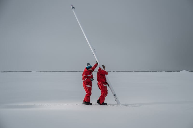 Researchers installing an ice mass balance buoy, which autonomously measures the temperature and thickness of sea ice, recording growth and melt over the year in the Arctic Ocean. Photograph: Esther Horvath/New York Times