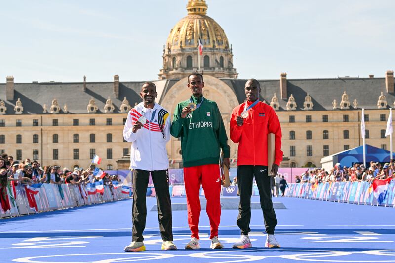 Silver medallist Belgium's Bashir Abdi, gold medallist Ethiopia's Tamirat Tola and bronze medallist Kenya's Benson Kipruto pose after the medal ceremony. Photograph: Andrej Isakovic/AFP via Getty