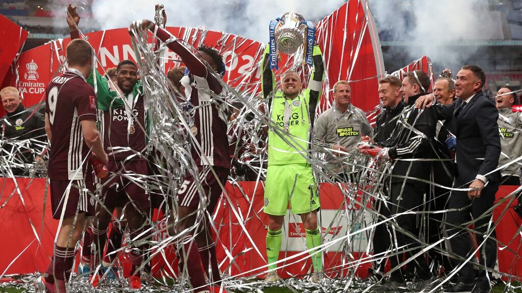 Leicester City’s Danish goalkeeper Kasper Schmeichel holds up the trophy as the Leicester players celebrate victory over Chelsea in the FA Cup final at Wembley Stadium north west London. Photograph: Nick Potts/AFP/Getty Images