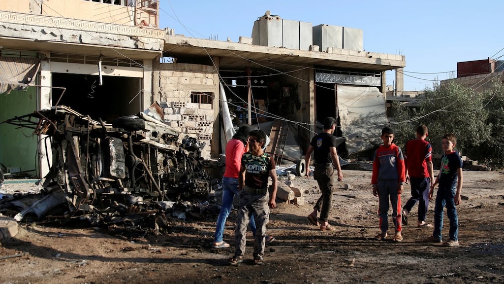 People walk at a site hit by an airstrike in the rebel-held Tafas town, in Deraa Governorate on Monday. Photograph: Alaa Al-Faqir/Reuters