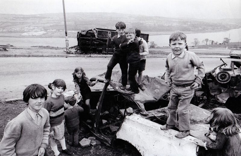 Children play on burned out cars in Derry, 1972. Photograph: PL Gould/Images/Getty Images
