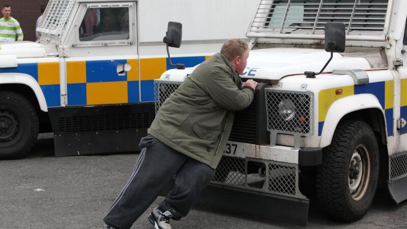 A nationalist protester stands in front of a PSNI vehicle to block its path in the Oldpark Road area of North Belfast after a contentious republican parade was stopped from entering Belfast city centre. Photograph: Stephen Kilkenny/PA Wire.