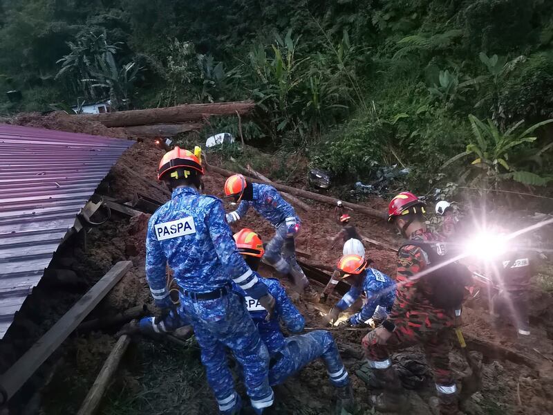 Rescuers search for another 12 people who are feared to be buried among the debris. Photograph: Malaysia Civil Defence/AP