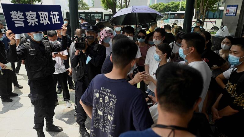 Police officers monitor a gathering at the Evergrande headquarters in Shenzhen, China. Photograph:  Noel Celis/AFP/Getty Image