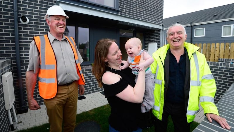 Helen Cheevers with baby Erik outside her new home at Baile na Laochra in Ballymun, Dublin, with Hugh Brennan (l) of the Ó Cualann Cohousing Alliance and architect Joe Kennedy. Photograph: Cyril Byrne