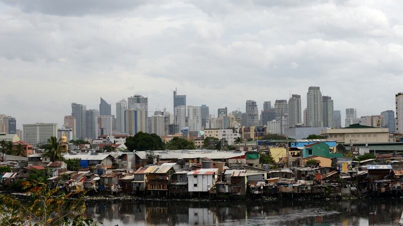 Shanty houses on the banks of a river by Manila’s financial district. Photograph: Noel Celis/AFP/Getty Images