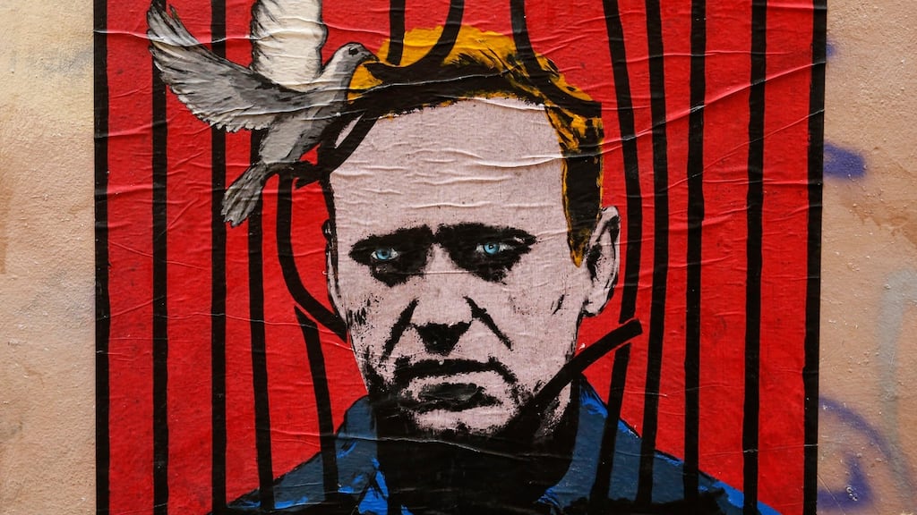 Poster depicting Russian opposition leader Alexei Navalny behind bars with a dove freeing him, by street artist Harry Greb, in Rome. Photograph: EPA/Fabio Frustaci
