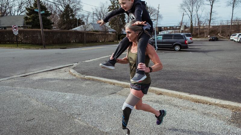 Amy Palmiero-Winters gives her fiancé’s son, Chase, (7), a ride as she trained for the Marathon des Sables in Farmingdale, New York last March. Photograph: Ryan Christopher Jones/The New York Times