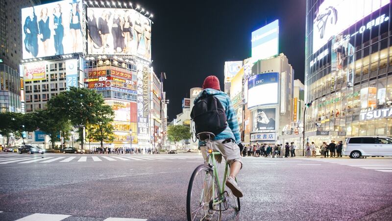 A man rides his bike at Shibuya crossing in Tokyo, Japan