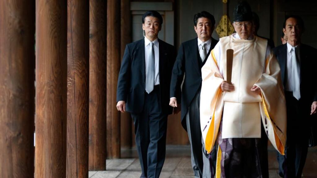 Japan’s prime minister Shinzo Abe (second from left) is led by a Shinto priest as he visits Yasukuni Shrine in Tokyo on December 26th, 2013. Photograph: Toru Hanai/Reuters