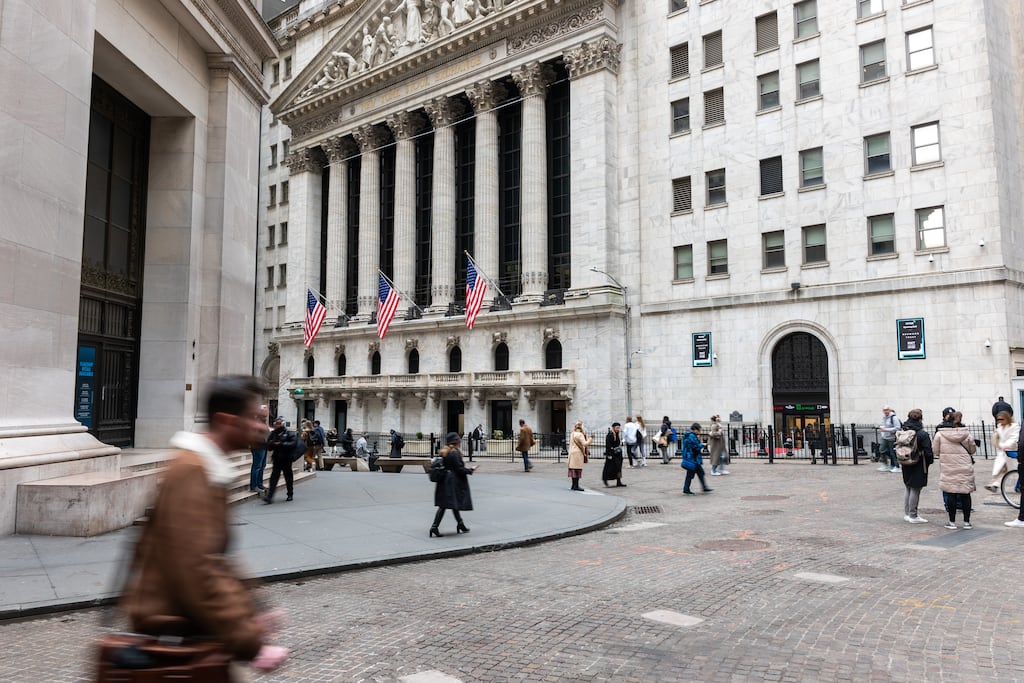 People walking by the New York Stock Exchange. The Dow was up slightly in late morning trading as traders waited for the Federal Reserve's latest decision on interest rates. Photograph: Spencer Platt/Getty Images