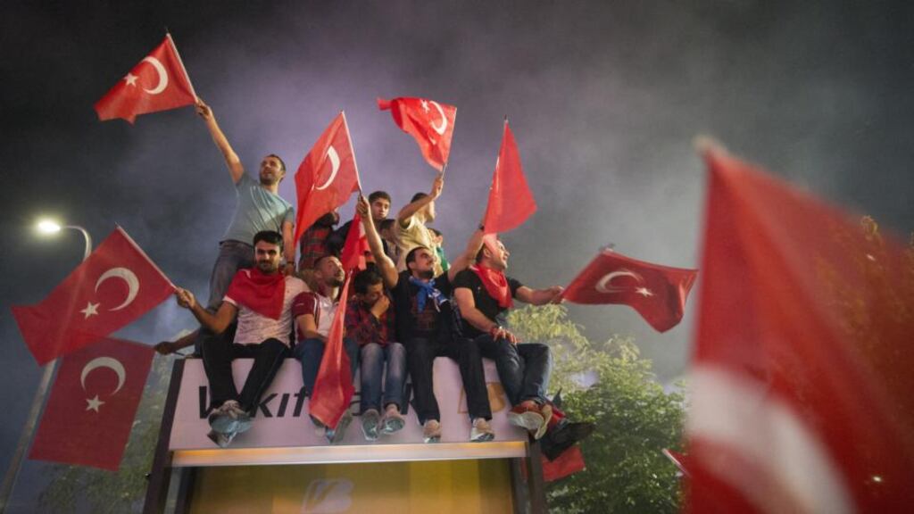 Mixed reception: supporters of the Turkish prime minister, Recep Tayyip Erdogan, wave the national flag on Friday as Erdogan returns to Istanbul from a tour of North Africa. At the same time, thousands of people protested at Taksim Square, in the centre of Istanbul. Photograph: Uriel Sinai/Getty Images