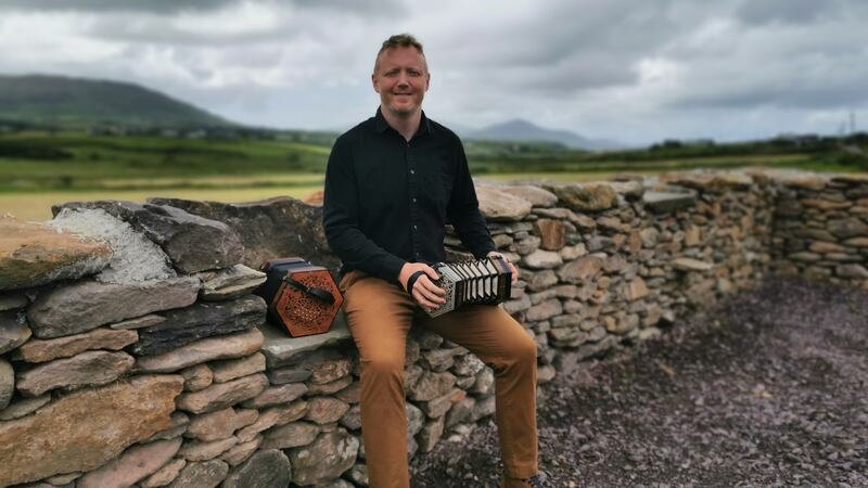 Musician Cormac Begley on the wall he built with Breanndán Begley and Johnny Dhónaillín.