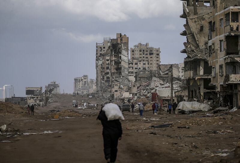 A Palestinian man walks past destroyed buildings in the streets of Gaza City. Photograph: Mohammed Saber/EPA