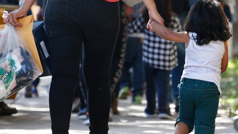A little girl and a woman along with other migrant families cross the street after being processed at the Central Bus Station before being taken to Catholic Charities before being removed in McAllen, Texas. Photograph: EPA