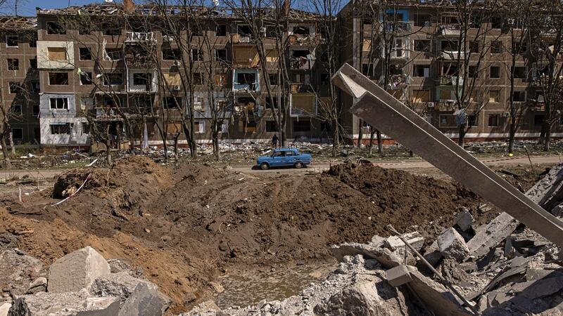 A car drives past a crater and a damaged apartment building in Kramatorsk, Donetsk region, eastern Ukraine. Photograph: Roman Pilipey/EPA